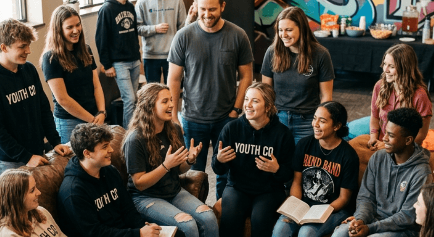 Diverse youth group sitting together with Bibles open during a devotional discussion